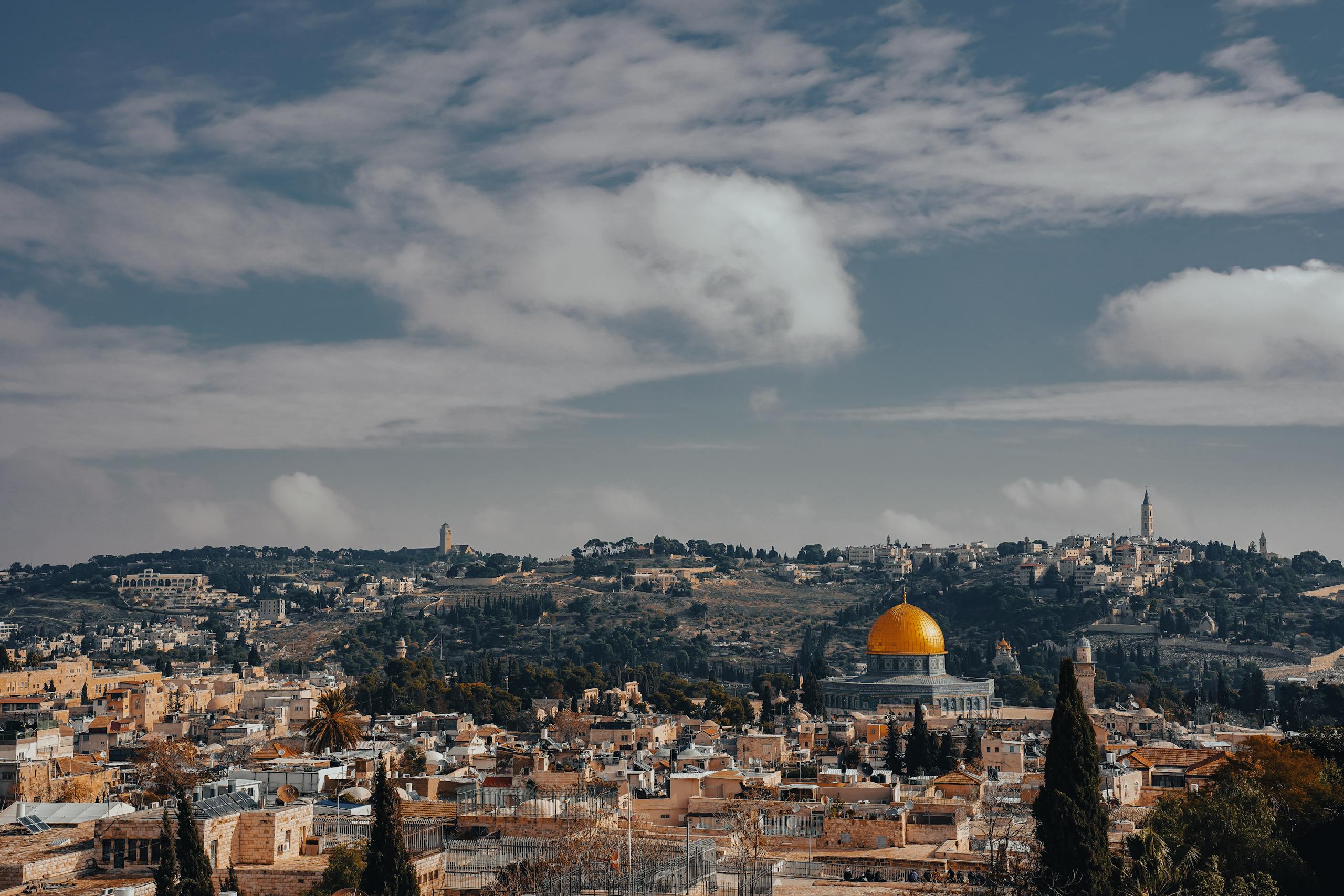 Stunning aerial view of Jerusalem cityscape with iconic Dome of the Rock amidst historical landmarks.